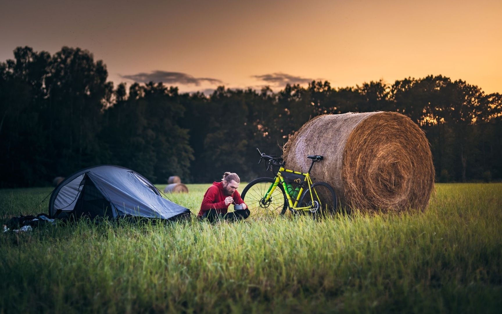 Cycliste en bivouac avec tente et vélo près d