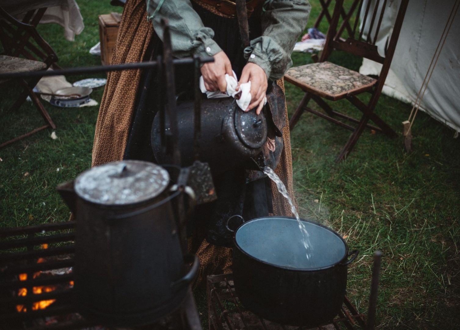Eau versée dans un seau au campement, près d